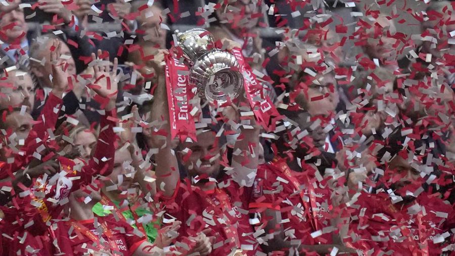 Liverpool players hold the trophy and celebrate after winning the English FA Cup final soccer match between Chelsea and Liverpool, at Wembley stadium, in London, Saturday, May 14, 2022. (AP Photo/Kirsty Wigglesworth)