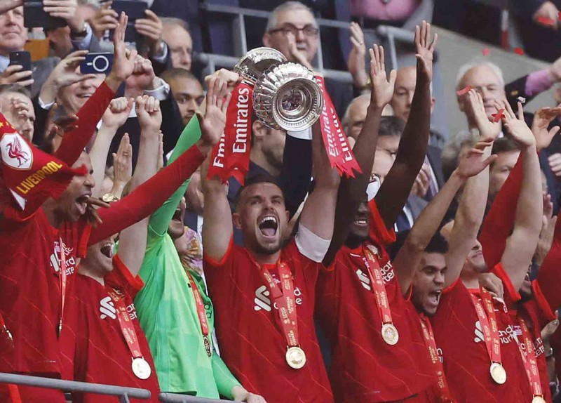 Britain Soccer FA Cup Final Liverpool players hold the trophy and celebrate after winning the English FA Cup final soccer match between Chelsea and Liverpool, at Wembley stadium, in London, Saturday, May 14, 2022. (AP Photo/Kirsty Wigglesworth)