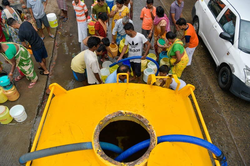 Orang-orang beristirahat di bawah jembatan di dasar Sungai Yamuna pada hari musim panas di New Delhi. (Anadolu Agency via Getty Images/Anadolu Agency)