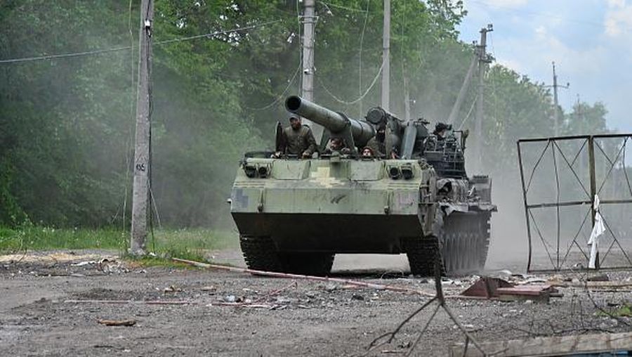 Tentara Ukraina mengendarai howitzer self-propelled di jalan di wilayah Kharkiv pada 17 Mei 2022, di tengah invasi Rusia ke Ukraina. (Foto oleh SERGEY BOBOK/AFP via Getty Images)