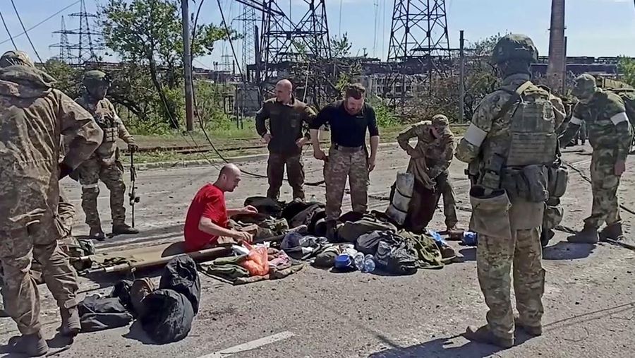 Anggota pasukan Ukraina yang telah menyerah setelah berminggu-minggu bersembunyi di pabrik baja Azovstal sedang digeledah oleh militer pro-Rusia di Mariupol, Ukraina, dalam gambar diam yang diambil dari video yang dirilis 18 Mei 2022. (via REUTERS/RUSSIAN DEFENCE MINISTRY)
