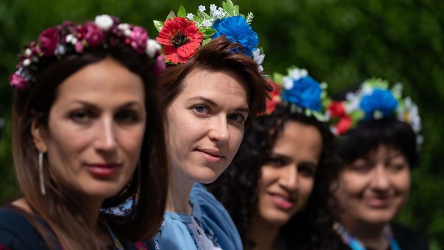Kristina Korniiuk, 34, (ketiga kanan) yang berasal dari Kyiv dan melarikan diri dari Ukraina setelah invasi Rusia, menandai perayaan Hari Vyshyvanka di Ukraina dengan kemeja tradisional raksasa, di rumah tuan rumahnya Rend Platings (ketiga kiri) di Cambridge . Kristina bergabung dengan rekan sesama Ukrania Anastasiia Romaniuk (kanan) dan saudara perempuan Alla Marich (kiri) dan Iryna Marich (kedua kiri). Tanggal foto: Kamis 19 Mei 2022. (Joe Giddens/PA Images via Getty Images)