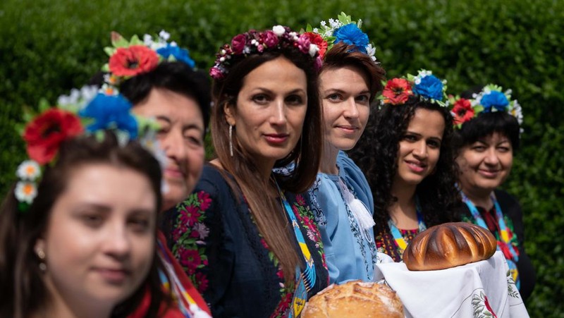 Kristina Korniiuk, 34, (ketiga kanan) yang berasal dari Kyiv dan melarikan diri dari Ukraina setelah invasi Rusia, menandai perayaan Hari Vyshyvanka di Ukraina dengan kemeja tradisional raksasa, di rumah tuan rumahnya Rend Platings (ketiga kiri) di Cambridge . Kristina bergabung dengan rekan sesama Ukrania Anastasiia Romaniuk (kanan) dan saudara perempuan Alla Marich (kiri) dan Iryna Marich (kedua kiri). Tanggal foto: Kamis 19 Mei 2022. (Joe Giddens/PA Images via Getty Images)