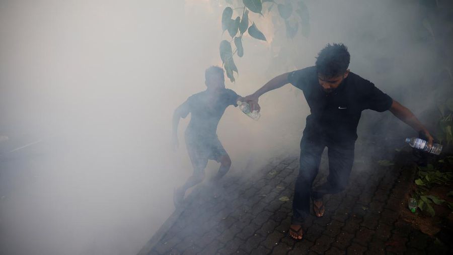 Mahasiswa Sri Lanka melarikan diri dari meriam air dan gas air mata saat para pengunjuk rasa bentrok dengan polisi melawan pemerintah di dekat kediaman resmi presiden Gotabaya Rajapaksa di Kolombo, Sri Lanka. (NurPhoto via Getty Images/NurPhoto)