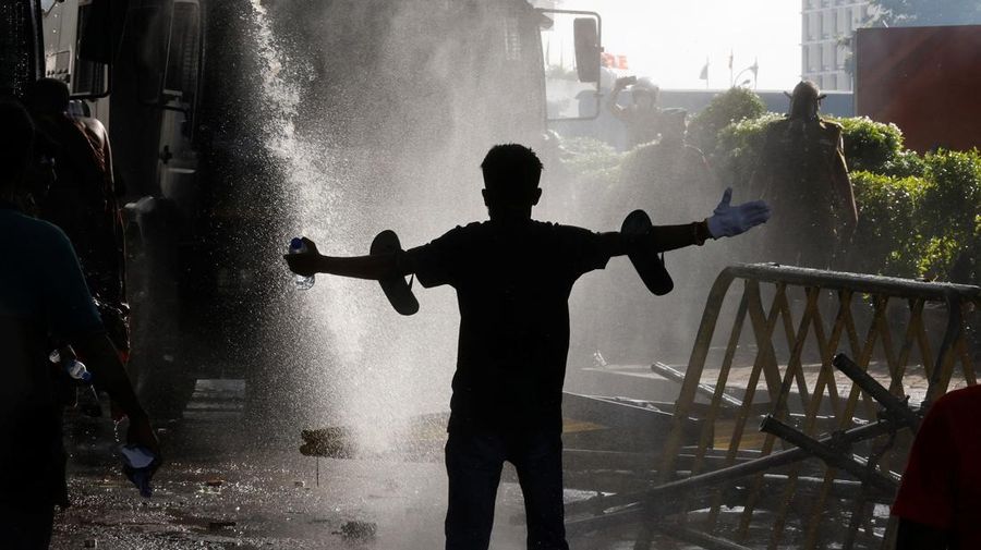 Mahasiswa Sri Lanka melarikan diri dari meriam air dan gas air mata saat para pengunjuk rasa bentrok dengan polisi melawan pemerintah di dekat kediaman resmi presiden Gotabaya Rajapaksa di Kolombo, Sri Lanka. (NurPhoto via Getty Images/NurPhoto)