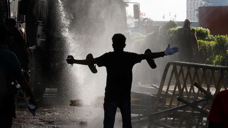 Mahasiswa Sri Lanka melarikan diri dari meriam air dan gas air mata saat para pengunjuk rasa bentrok dengan polisi melawan pemerintah di dekat kediaman resmi presiden Gotabaya Rajapaksa di Kolombo, Sri Lanka. (NurPhoto via Getty Images/NurPhoto)