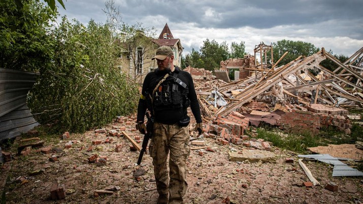 Seorang tentara pertahanan wilayah Ukraina berjalan melewati reruntuhan sebuah bangunan yang terkena tembakan di pinggiran wilayah separatis Donetsk (Donbas).. (LightRocket via Gett/SOPA Images)
