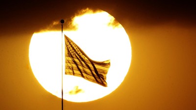 The United State flag is silhouetted against the setting sun Sunday, May 28, 2017, in Leavenworth, Kan. (AP Photo/Charlie Riedel)