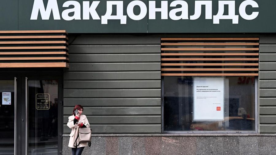 A woman speaks on a smartphone in front of a closed McDonald's restaurant in Moscow on May 16, 2022. - American fast-food giant McDonald's will exit the Russian market and sell its business in the increasingly isolated country, the company said May 16, 2022. In a statement McDonald's said: