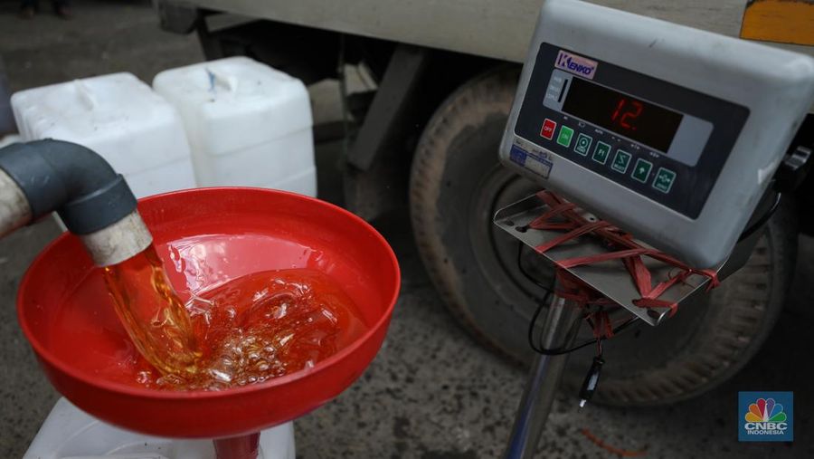 Pekerja mengisi minyak goreng curah bersubsidi ke dalam jerigen di pasar Kebayoran Lama, Jakarta, Senin (23/5/2022). Operasi pasar tersebut menyediakan minyak goreng curah subsidi sebanyak 8000 liter dengan harga Rp 14.000 per liter atau Rp 15.500 per kilogram untuk mencukupi kebutuhaan masyarakat. (CNBC Indonesoa/ Tri Susilo)