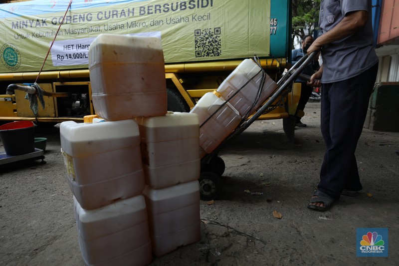 Pekerja mengisi minyak goreng curah bersubsidi ke dalam jerigen di pasar Kebayoran Lama, Jakarta, Senin (23/5/2022). Operasi pasar tersebut menyediakan minyak goreng curah subsidi sebanyak 8000 liter dengan harga Rp 14.000 per liter atau Rp 15.500 per kilogram untuk mencukupi kebutuhaan masyarakat. (CNBC Indonesoa/ Tri Susilo)