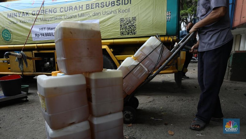 Pekerja mengisi minyak goreng curah bersubsidi ke dalam jerigen di pasar Kebayoran Lama, Jakarta, Senin (23/5/2022). Operasi pasar tersebut menyediakan minyak goreng curah subsidi sebanyak 8000 liter dengan harga Rp 14.000 per liter atau Rp 15.500 per kilogram untuk mencukupi kebutuhaan masyarakat. (CNBC Indonesoa/ Tri Susilo)