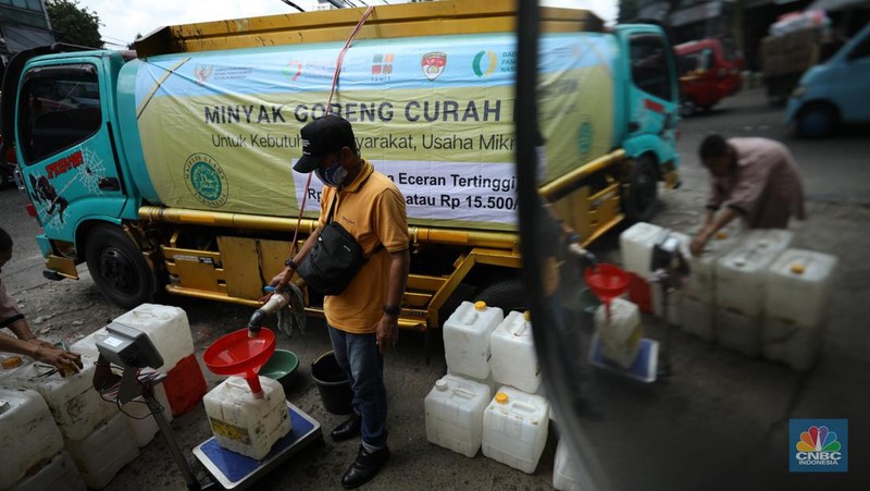 Pekerja mengisi minyak goreng curah bersubsidi ke dalam jerigen di pasar Kebayoran Lama, Jakarta, Senin (23/5/2022). Operasi pasar tersebut menyediakan minyak goreng curah subsidi sebanyak 8000 liter dengan harga Rp 14.000 per liter atau Rp 15.500 per kilogram untuk mencukupi kebutuhaan masyarakat. (CNBC Indonesoa/ Tri Susilo)