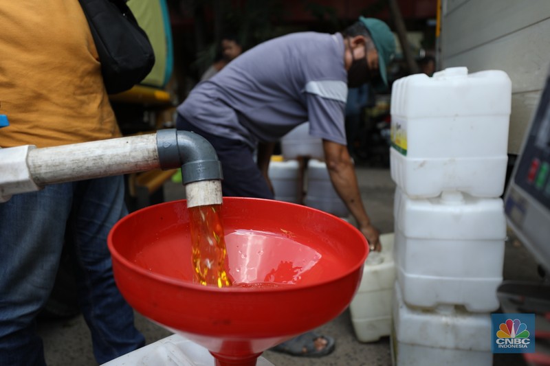 Oeprasi Pasar Minyak goreng curah bersubsidi Pekerja mengisi minyak goreng curah bersubsidi ke dalam jerigen di pasar Kebayoran Lama, Jakarta, Senin (23/5/2022). Operasi pasar tersebut menyediakan minyak goreng curah subsidi sebanyak 8000 liter dengan harga Rp 14.000 per liter atau Rp 15.500 per kilogram untuk mencukupi kebutuhaan masyarakat. (CNBC Indonesoa/ Tri Susilo)