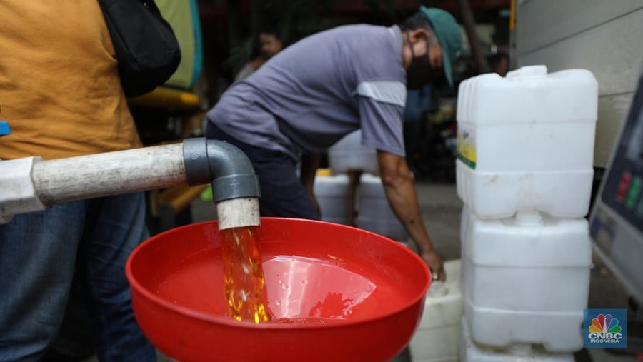 Pekerja mengisi minyak goreng curah bersubsidi ke dalam jerigen di pasar Kebayoran Lama, Jakarta, Senin (23/5/2022). Operasi pasar tersebut menyediakan minyak goreng curah subsidi sebanyak 8000 liter dengan harga Rp 14.000 per liter atau Rp 15.500 per kilogram untuk mencukupi kebutuhaan masyarakat. (CNBC Indonesoa/ Tri Susilo)