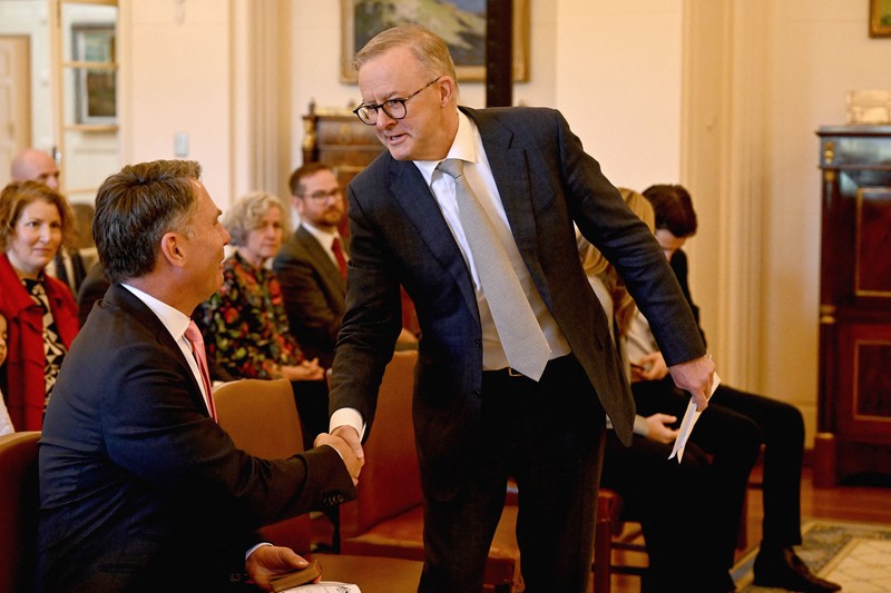 Perdana Menteri baru Australia Anthony Albanese (kanan) berjabat tangan dengan wakil Perdana Menteri Richard Marles Perdana Menteri baru Australia Anthony Albanese (kanan) berjabat tangan dengan wakil Perdana Menteri Richard Marles saat upacara pengambilan sumpah di Gedung Pemerintah di Canberra, Australia, Senin (23/5/2022). (Photo by SAEED KHAN/AFP via Getty Images)