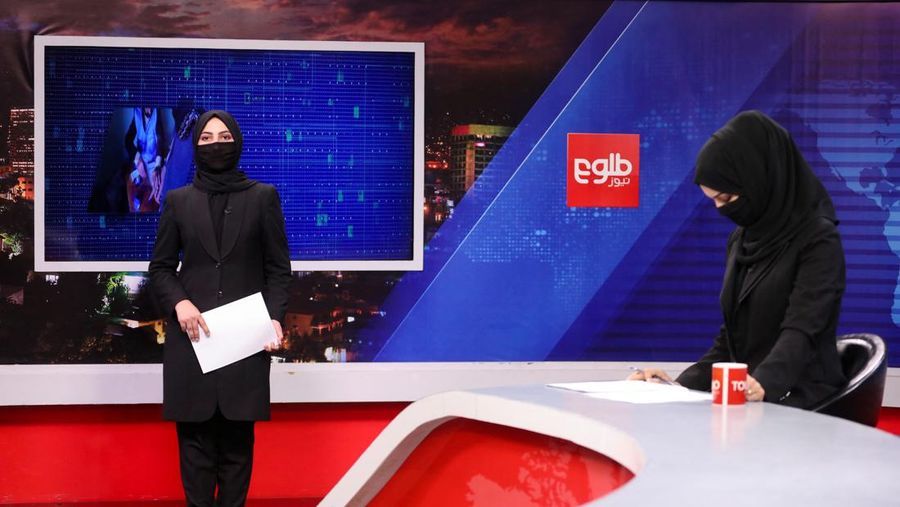 Presenter wanita untuk TOLOnews, Thamina Usmani, bersiap untuk siaran langsungnya di stasiun TV Tolo di Kabul, Afghanistan, Minggu (22/5/2022). Taliban menambah panjang aturan dengan mewajibkan presenter perempuan di Afghanistan menutup wajah saat siaran langsung di televisi. (Photo by WAKIL KOHSAR/AFP via Getty Images)