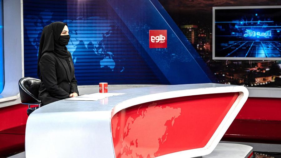 Presenter wanita untuk TOLOnews, Thamina Usmani, bersiap untuk siaran langsungnya di stasiun TV Tolo di Kabul, Afghanistan, Minggu (22/5/2022). Taliban menambah panjang aturan dengan mewajibkan presenter perempuan di Afghanistan menutup wajah saat siaran langsung di televisi. (Photo by WAKIL KOHSAR/AFP via Getty Images)