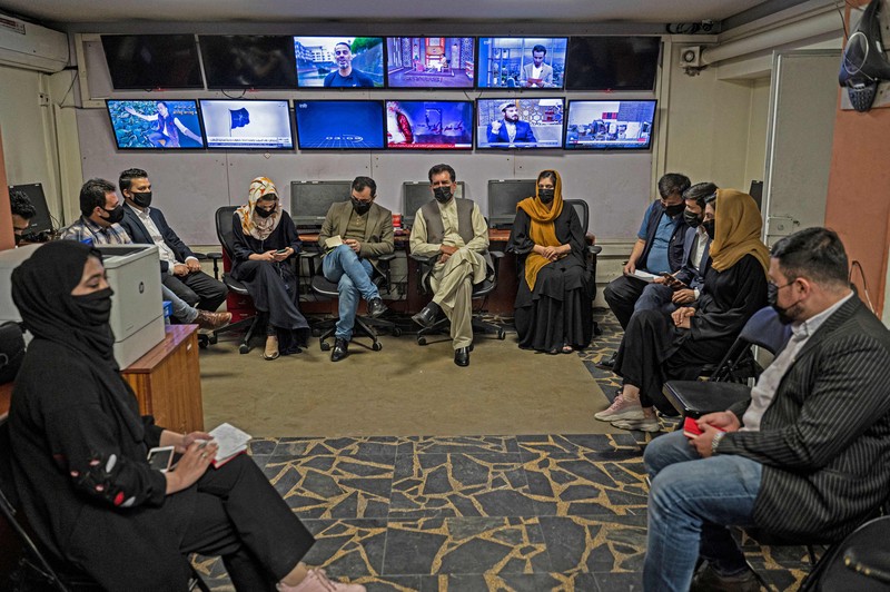 Presenter wanita untuk TOLOnews, Thamina Usmani, bersiap untuk siaran langsungnya di stasiun TV Tolo di Kabul, Afghanistan, Minggu (22/5/2022). Taliban menambah panjang aturan dengan mewajibkan presenter perempuan di Afghanistan menutup wajah saat siaran langsung di televisi. (Photo by WAKIL KOHSAR/AFP via Getty Images)