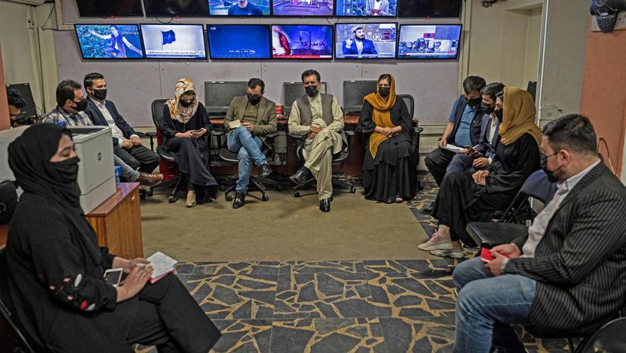 Presenter wanita untuk TOLOnews, Thamina Usmani, bersiap untuk siaran langsungnya di stasiun TV Tolo di Kabul, Afghanistan, Minggu (22/5/2022). Taliban menambah panjang aturan dengan mewajibkan presenter perempuan di Afghanistan menutup wajah saat siaran langsung di televisi. (Photo by WAKIL KOHSAR/AFP via Getty Images)