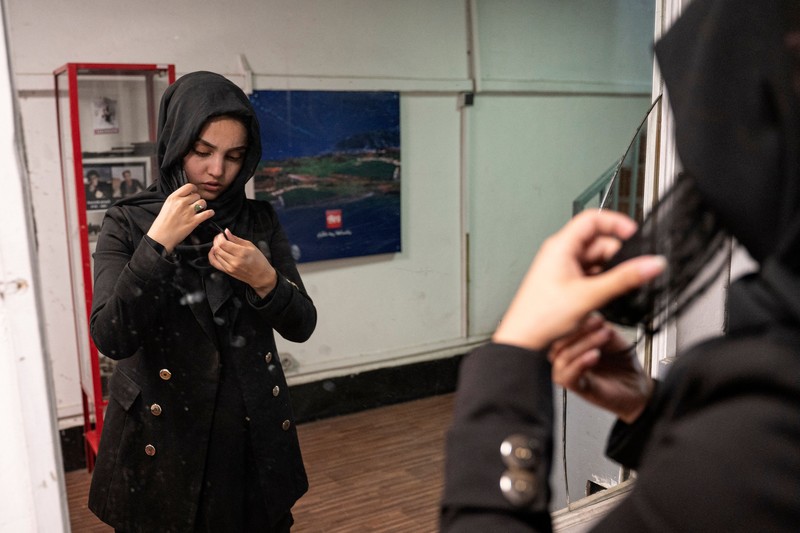 Presenter wanita untuk TOLOnews, Thamina Usmani, bersiap untuk siaran langsungnya di stasiun TV Tolo di Kabul, Afghanistan, Minggu (22/5/2022). Taliban menambah panjang aturan dengan mewajibkan presenter perempuan di Afghanistan menutup wajah saat siaran langsung di televisi. (Photo by WAKIL KOHSAR/AFP via Getty Images)