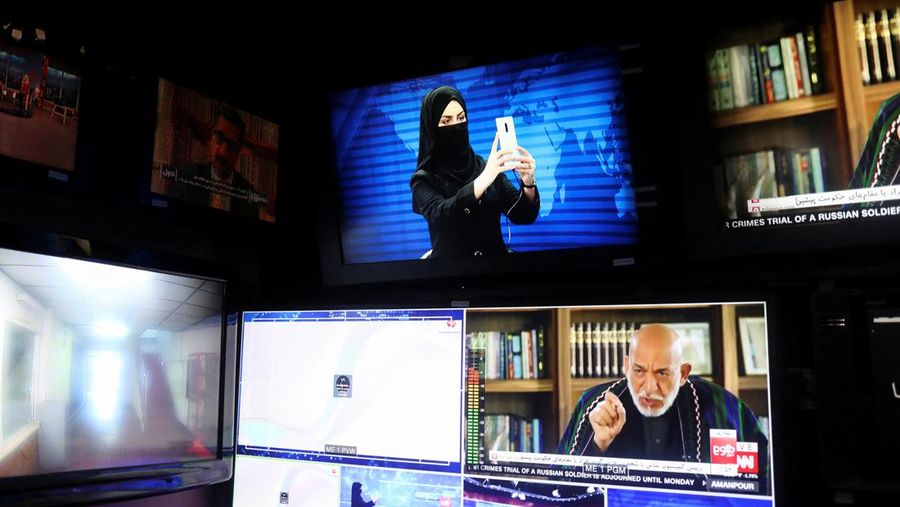 Presenter wanita untuk TOLOnews, Thamina Usmani, bersiap untuk siaran langsungnya di stasiun TV Tolo di Kabul, Afghanistan, Minggu (22/5/2022). Taliban menambah panjang aturan dengan mewajibkan presenter perempuan di Afghanistan menutup wajah saat siaran langsung di televisi. (Photo by WAKIL KOHSAR/AFP via Getty Images)