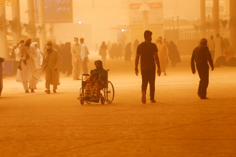 Badai Pasir di Irak Sejumlah warga beraktivtas saat badai pasir di Najaf, Irak, Senin (23/5/2022). (REUTERS/Alaa Al-Marjani)