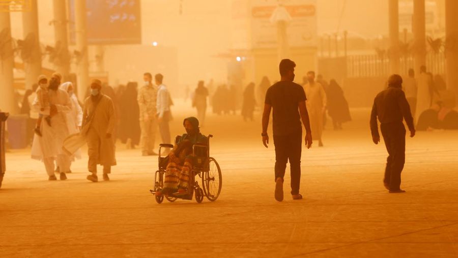 Sejumlah warga beraktivtas saat badai pasir di Najaf, Irak, Senin (23/5/2022). (REUTERS/Alaa Al-Marjani)