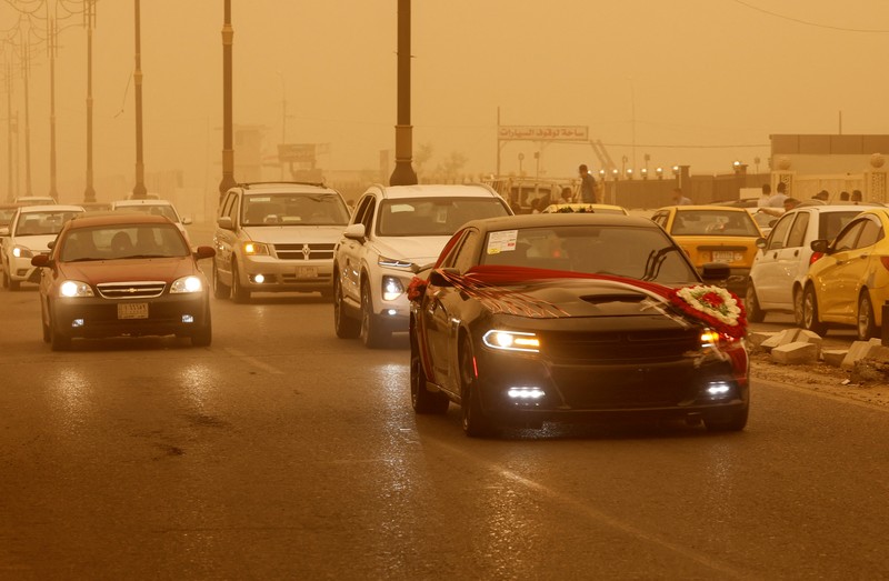 Badai Pasir di Irak Sejumlah warga beraktivtas saat badai pasir di Najaf, Irak, Senin (23/5/2022). (REUTERS/Alaa Al-Marjani)