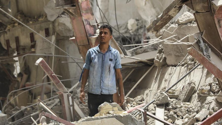 Warga Iran berkumpul di lokasi di mana sebuah bangunan sepuluh lantai runtuh di barat daya kota Abadan, Iran, Senin (23/5/2022).  Kejadian tersebut menyebabkan beberapa orang meninggal dan sekitar 80 orang terperangkap di bawah reruntuhan ketika sebuah bangunan yang belum selesai roboh di barat daya Iran. (Photo by -/TASNIM NEWS/AFP via Getty Images)