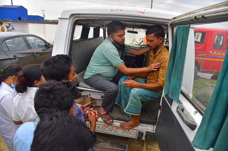 Anak-anak menaiki rakit bambu melewati daerah banjir setelah hujan lebat di distrik Morigaon, negara bagian Assam, India, Minggu (22/5/2022). Banjir adalah ancaman biasa bagi jutaan orang di dataran rendah Bangladesh dan tetangga timur laut India, tetapi banyak ahli mengatakan bahwa perubahan iklim meningkatkan frekuensi, keganasan dan ketidakpastian. (Photo by BIJU BORO/AFP via Getty Images)