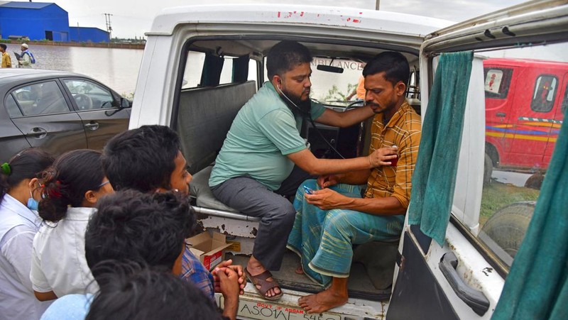 Anak-anak menaiki rakit bambu melewati daerah banjir setelah hujan lebat di distrik Morigaon, negara bagian Assam, India, Minggu (22/5/2022). Banjir adalah ancaman biasa bagi jutaan orang di dataran rendah Bangladesh dan tetangga timur laut India, tetapi banyak ahli mengatakan bahwa perubahan iklim meningkatkan frekuensi, keganasan dan ketidakpastian. (Photo by BIJU BORO/AFP via Getty Images)