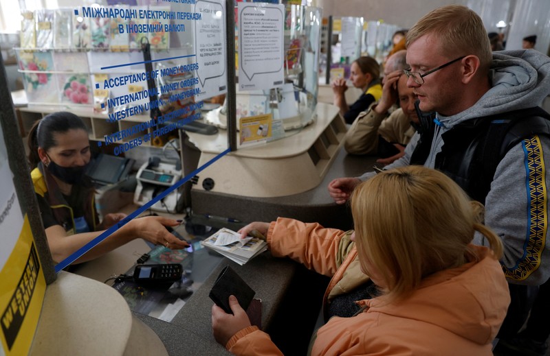 Orang-orang mengantre untuk membeli seri perangko peringatan prajurit Pulau Ular anti-Rusia ditengah serangan Rusia ke Ukraina, di Kyiv, Ukraina, Senin (23/5/2022). (REUTERS/Edgar Su)