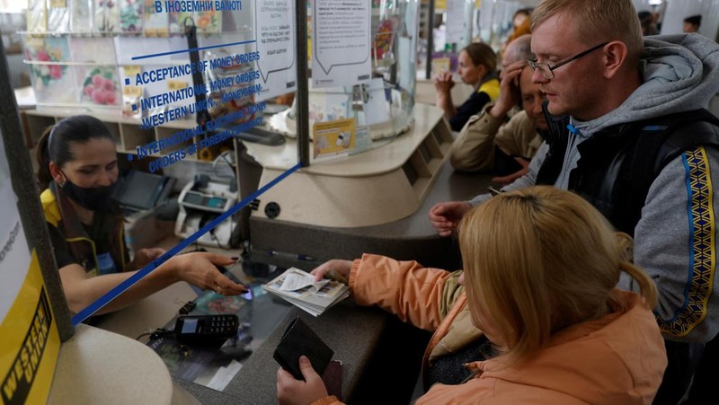 Orang-orang mengantre untuk membeli seri perangko peringatan prajurit Pulau Ular anti-Rusia ditengah serangan Rusia ke Ukraina, di Kyiv, Ukraina, Senin (23/5/2022). (REUTERS/Edgar Su)