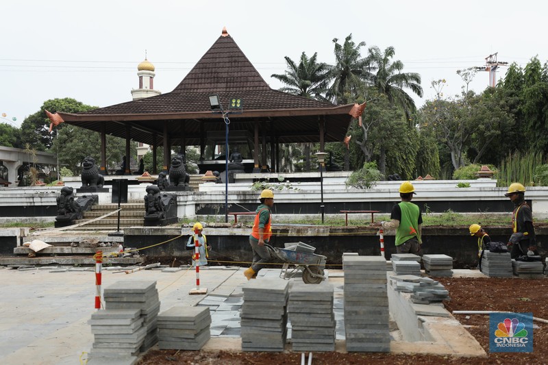 Proyek revitalisasi Taman Mini Indonesia Indah (TMII), Pekerja menyelesaikan pengerjaan revitalisasi Taman Mini Indonesia Indah (TMII), Jakarta, Selasa (24/5/2022). Langkah revitalisasi dilakukan dalam upaya mendukung kegiatan presidensi G20 di Indonesia pada tahun ini, sekaligus mengembalikan marwah dan fungsi awal dari TMII. (CNBC Indonesia/ Tri Susilo)
