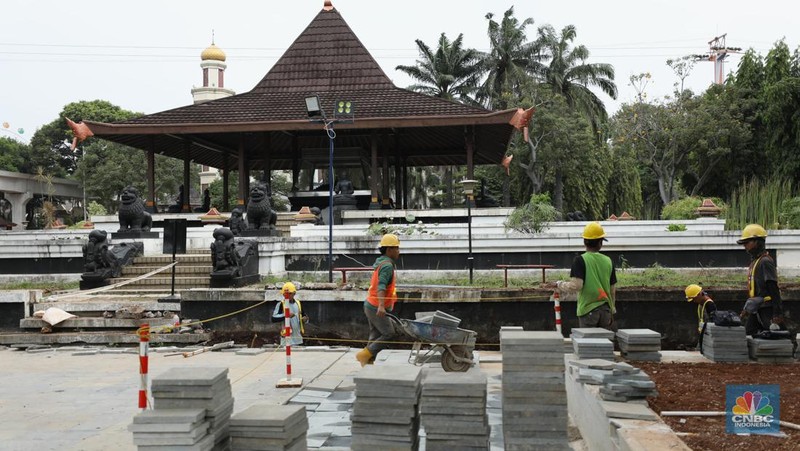Pekerja menyelesaikan pengerjaan revitalisasi Taman Mini Indonesia Indah (TMII), Jakarta, Selasa (24/5/2022). Langkah revitalisasi dilakukan dalam upaya mendukung kegiatan presidensi G20 di Indonesia pada tahun ini, sekaligus mengembalikan marwah dan fungsi awal dari TMII. (CNBC Indonesia/ Tri Susilo)