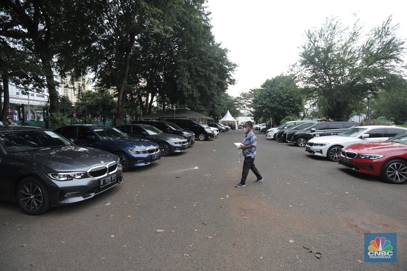 Warga melintas diparkiran BMW Seri 3 terbaru sebagai VIP Fleet dari BNI Java Jazz Festival 2022 kepada Dewi Gontha, President Director Java Festival Production di Jakarta, Rabu (25/5/2022). (CNBC Indonesia/ Muhammad Sabki)