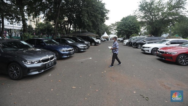 Warga melintas diparkiran BMW Seri 3 terbaru sebagai VIP Fleet dari BNI Java Jazz Festival 2022 kepada Dewi Gontha, President Director Java Festival Production di Jakarta, Rabu (25/5/2022). (CNBC Indonesia/ Muhammad Sabki)