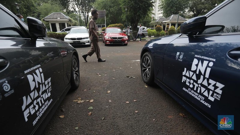 Warga melintas diparkiran BMW Seri 3 terbaru sebagai VIP Fleet dari BNI Java Jazz Festival 2022 kepada Dewi Gontha, President Director Java Festival Production di Jakarta, Rabu (25/5/2022). (CNBC Indonesia/ Muhammad Sabki)