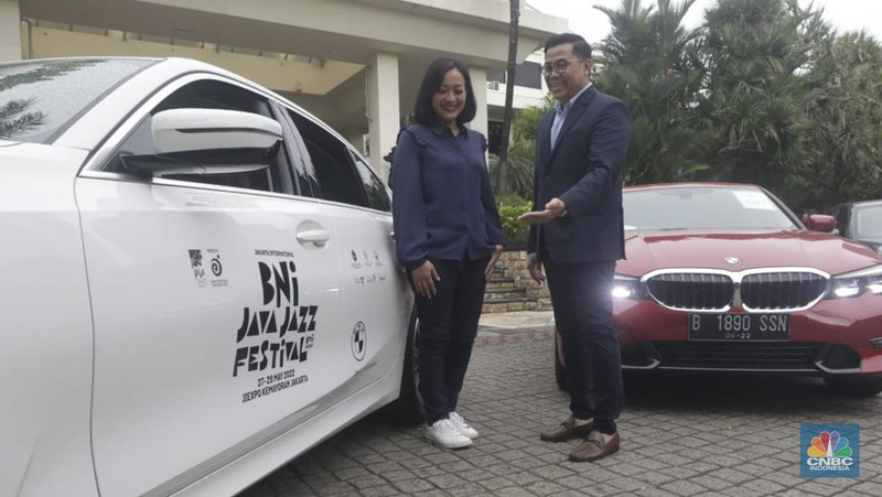 Warga melintas diparkiran BMW Seri 3 terbaru sebagai VIP Fleet dari BNI Java Jazz Festival 2022 kepada Dewi Gontha, President Director Java Festival Production di Jakarta, Rabu (25/5/2022). (CNBC Indonesia/ Muhammad Sabki)