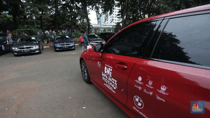 Warga melintas diparkiran BMW Seri 3 terbaru sebagai VIP Fleet dari BNI Java Jazz Festival 2022 kepada Dewi Gontha, President Director Java Festival Production di Jakarta, Rabu (25/5/2022). (CNBC Indonesia/ Muhammad Sabki)