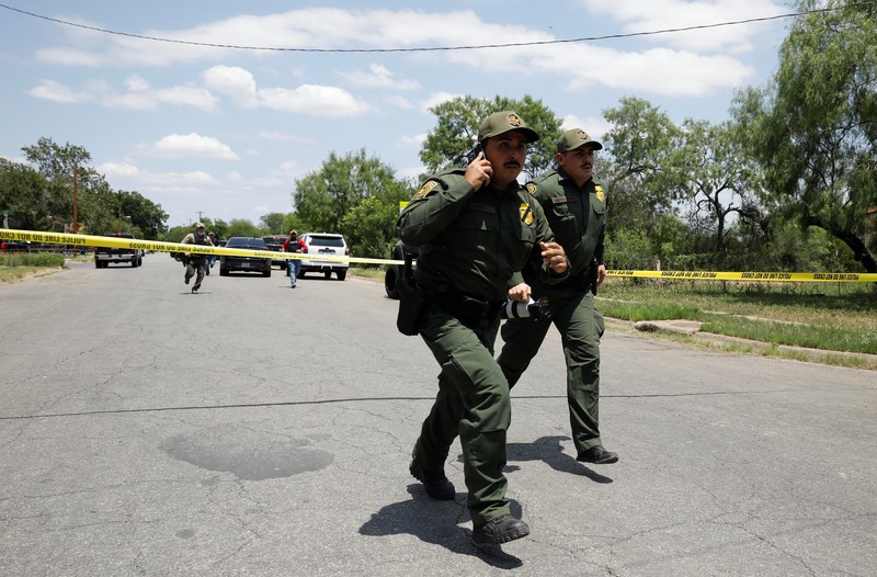 Kendaraan polisi diparkir di dekat sebuah mobil yang diyakini milik tersangka penembakan di Sekolah Dasar Robb setelah penembakan, di Uvalde, Texas, AS, Selasa (24/5/2022). (REUTERS/Marco Bello)