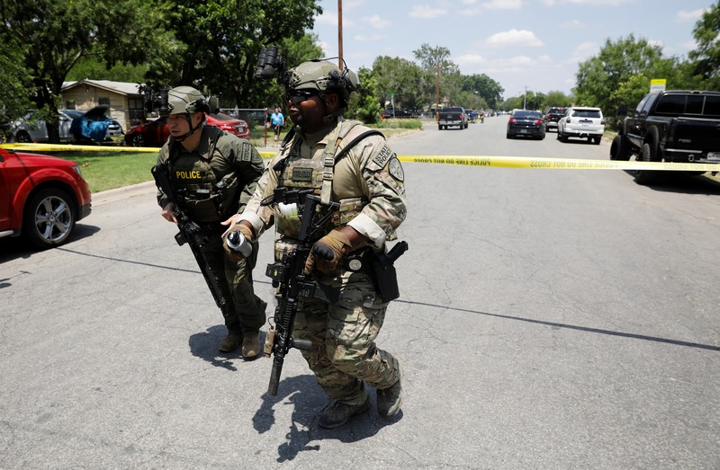 Kendaraan polisi diparkir di dekat sebuah mobil yang diyakini milik tersangka penembakan di Sekolah Dasar Robb setelah penembakan, di Uvalde, Texas, AS, Selasa (24/5/2022). (REUTERS/Marco Bello)