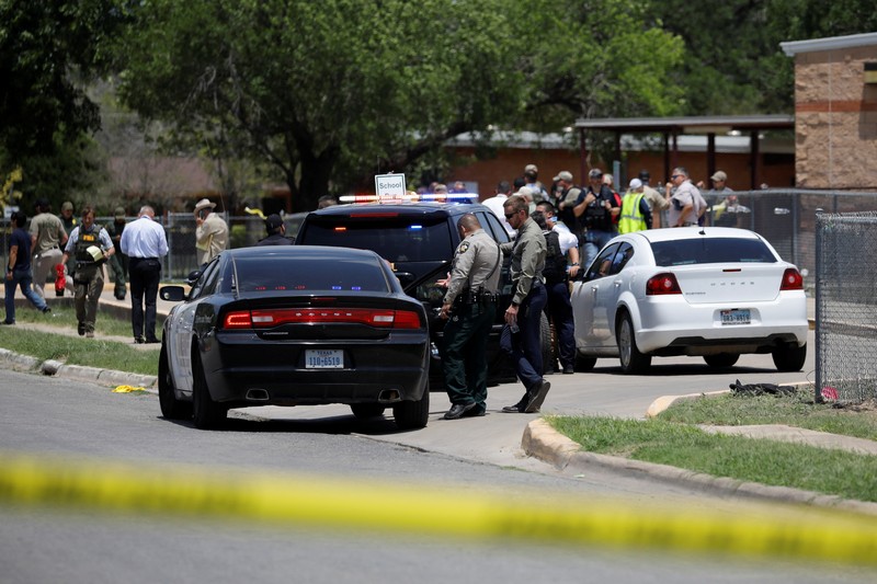 Kendaraan polisi diparkir di dekat sebuah mobil yang diyakini milik tersangka penembakan di Sekolah Dasar Robb setelah penembakan, di Uvalde, Texas, AS, Selasa (24/5/2022). (REUTERS/Marco Bello)