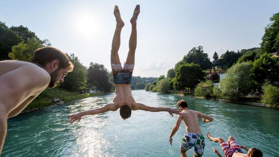TOPSHOT - Young men jump into the river Aare on June 21, 2017 in Bern.
Europe sizzled in a continent-wide heatwave with London bracing for Britain's hottest June day since 1976 as Portugal battled to stamp out deadly forest fires. Cooler weather was aiding their efforts, but thermometers were still hovering around 35 degrees Celsius (95 degrees Fahrenheit) -- a level matched across oven-like swathes of Europe, including Italy, Austria, the Netherlands and even alpine Switzerland. / AFP PHOTO / Fabrice COFFRINI (Photo credit should read FABRICE COFFRINI/AFP via Getty Images)