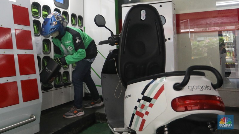 Pengemudi ojek daring mengganti baterai sepeda motor listriknya di stasiun pengisian baterai listrik (Swapping Station) di Kuningan, Jakarta, Senin (30/5/2022). (CNBC Indonesia/Andrean Kristianto)