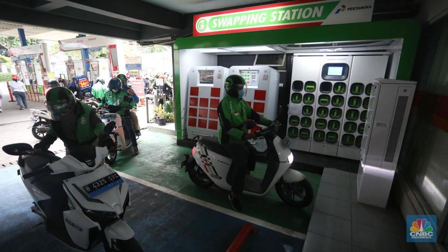 Pengemudi ojek daring mengganti baterai sepeda motor listriknya di stasiun pengisian baterai listrik (Swapping Station) di Kuningan, Jakarta, Senin (30/5/2022). (վ/Andrean Kristianto)