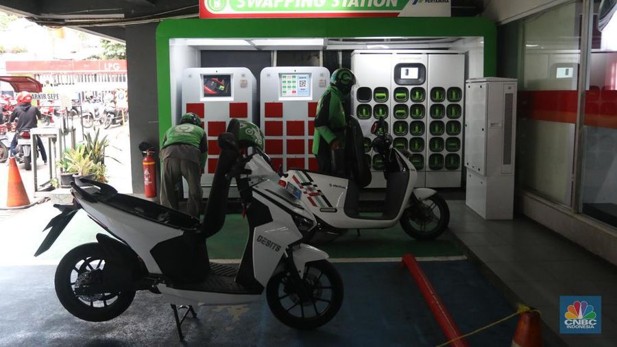 Pengemudi ojek daring mengganti baterai sepeda motor listriknya di stasiun pengisian baterai listrik (Swapping Station) di Kuningan, Jakarta, Senin (30/5/2022). (CNBC Indonesia/Andrean Kristianto)