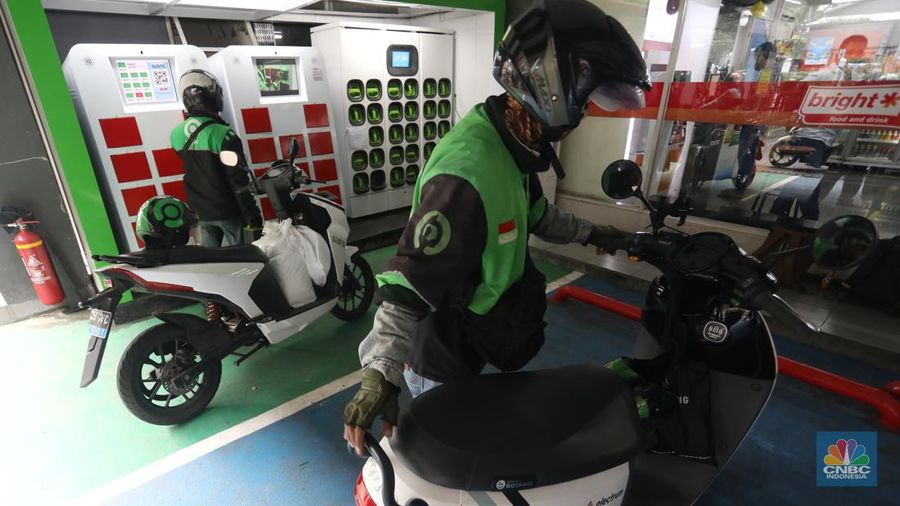 Pengemudi ojek daring mengganti baterai sepeda motor listriknya di stasiun pengisian baterai listrik (Swapping Station) di Kuningan, Jakarta, Senin (30/5/2022). (CNBC Indonesia/Andrean Kristianto)