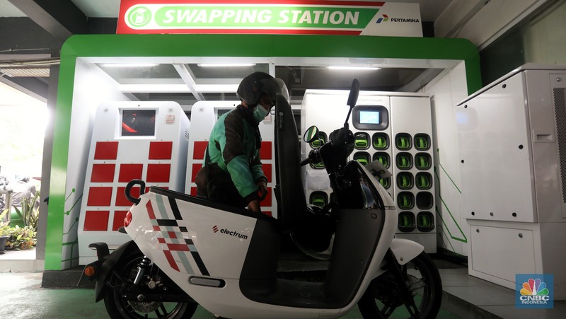 Pengemudi ojek daring mengganti baterai sepeda motor listriknya di stasiun pengisian baterai listrik (Swapping Station) di Kuningan, Jakarta, Senin (30/5/2022). (CNBC Indonesia/Andrean Kristianto)